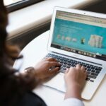 Woman Sitting Near Table Using Macbook