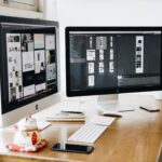 A well-organized design workspace with dual monitors and design software on display.