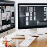 A well-organized design workspace with dual monitors and design software on display.